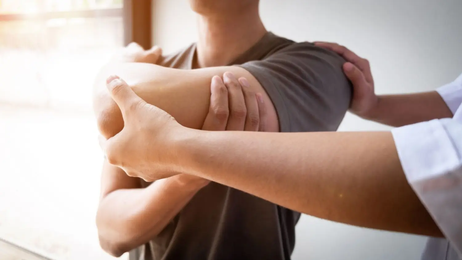 Agbalik Physiotherapie - Therapeutin behandelt einen Mann, der sich bei der Dehnungsmethode der Rotatorenmanschette verletzt hat.